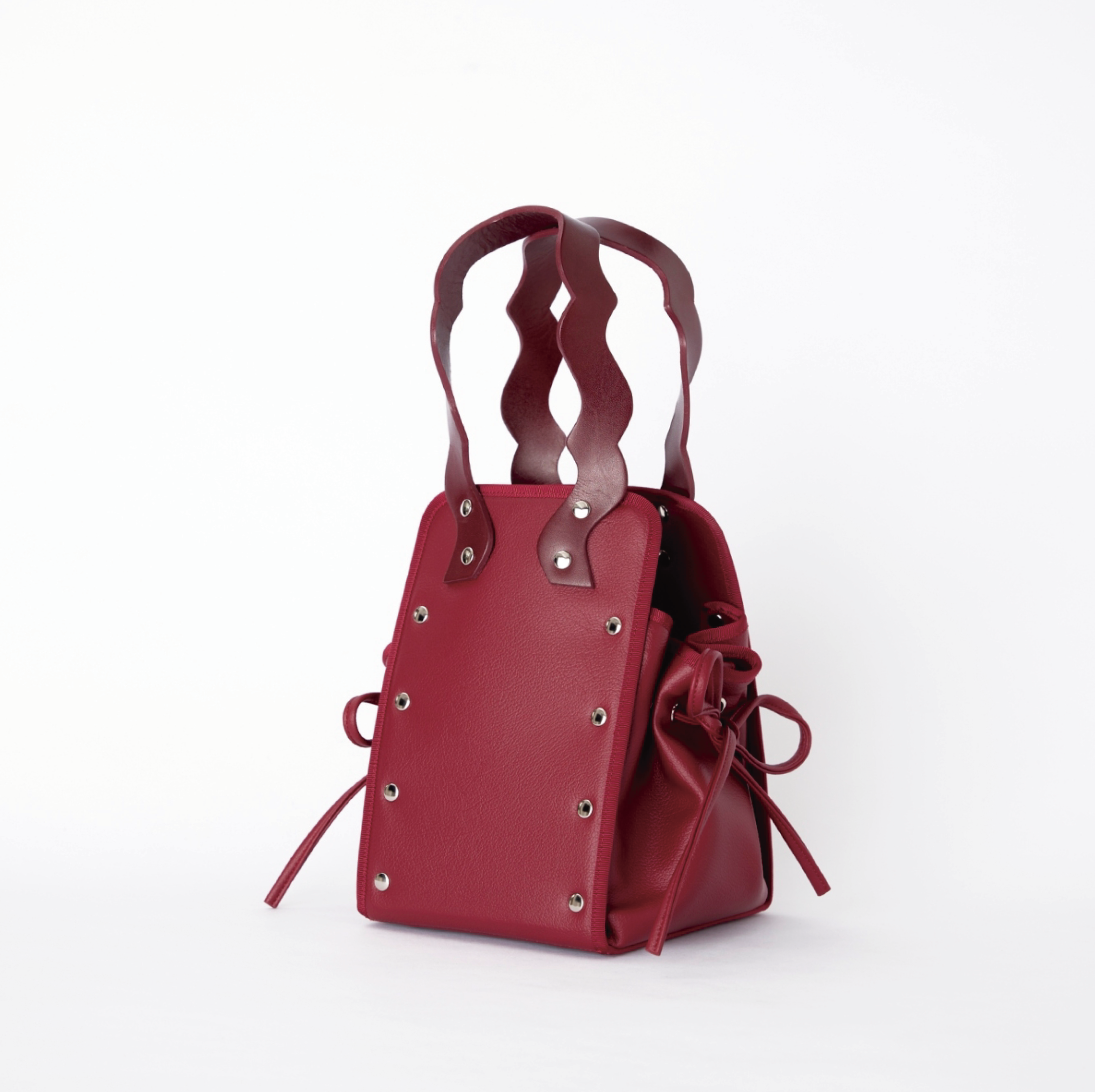 本革ハンドルの巾着型ハンドバッグ。サイドのドローストリングでシルエットを変化可能。500mlペットボトル対応サイズで内ポケット付き。取り外し可能なチェーンストラップでショルダー・クロスボディ両用。