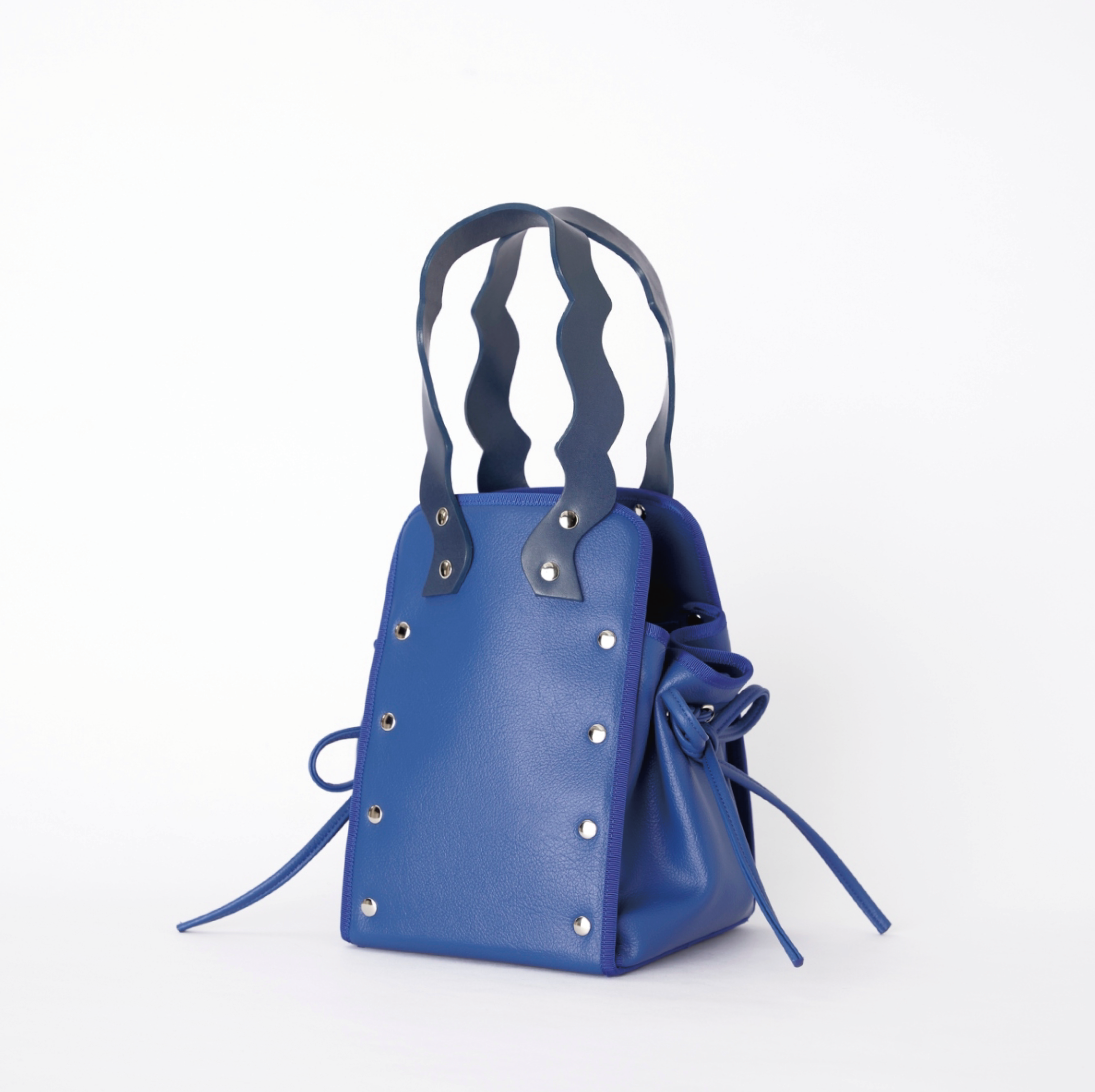 本革ハンドルの巾着型ハンドバッグ。サイドのドローストリングでシルエットを変化可能。500mlペットボトル対応サイズで内ポケット付き。取り外し可能なチェーンストラップでショルダー・クロスボディ両用。