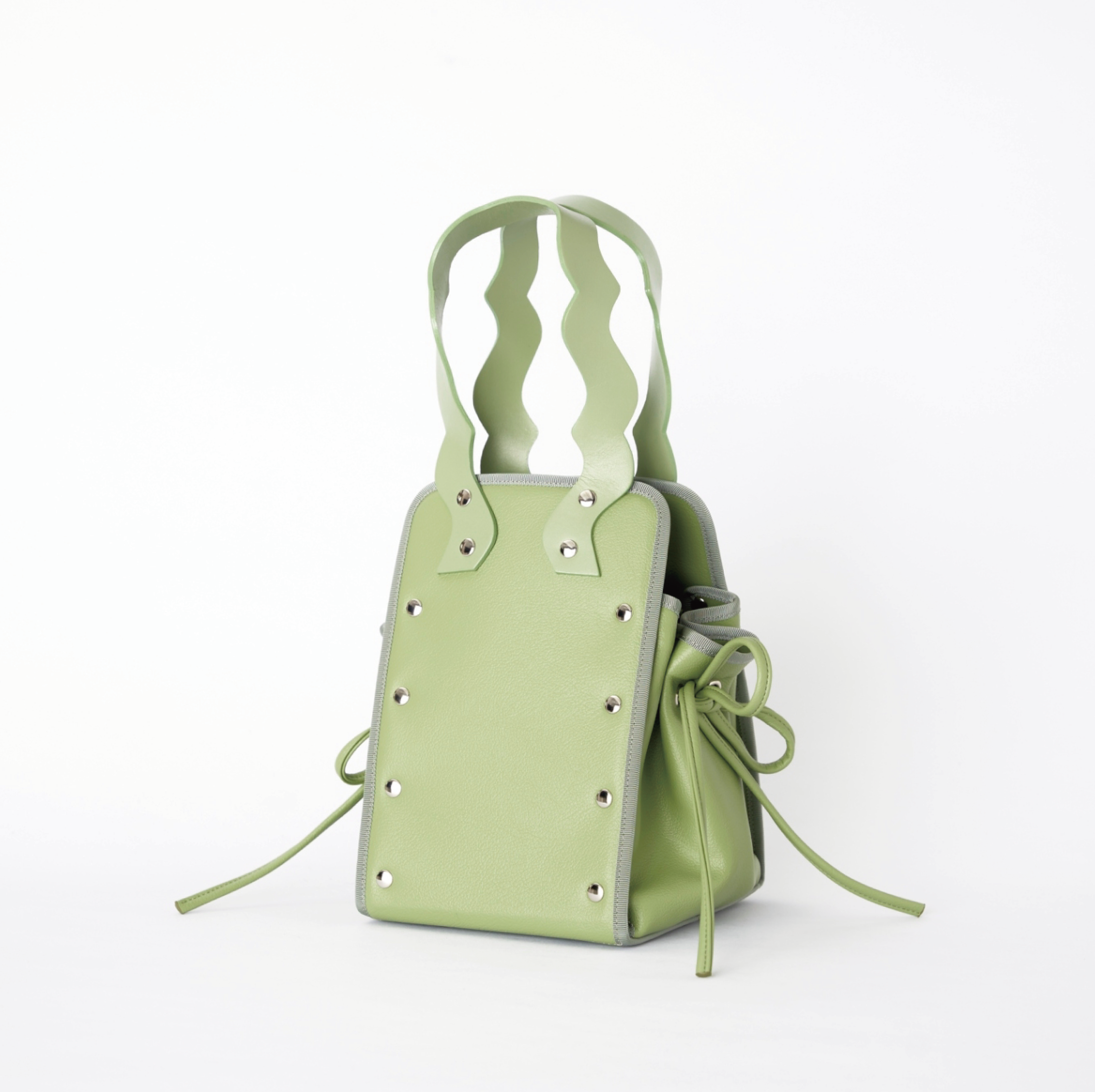 本革ハンドルの巾着型ハンドバッグ。サイドのドローストリングでシルエットを変化可能。500mlペットボトル対応サイズで内ポケット付き。取り外し可能なチェーンストラップでショルダー・クロスボディ両用。