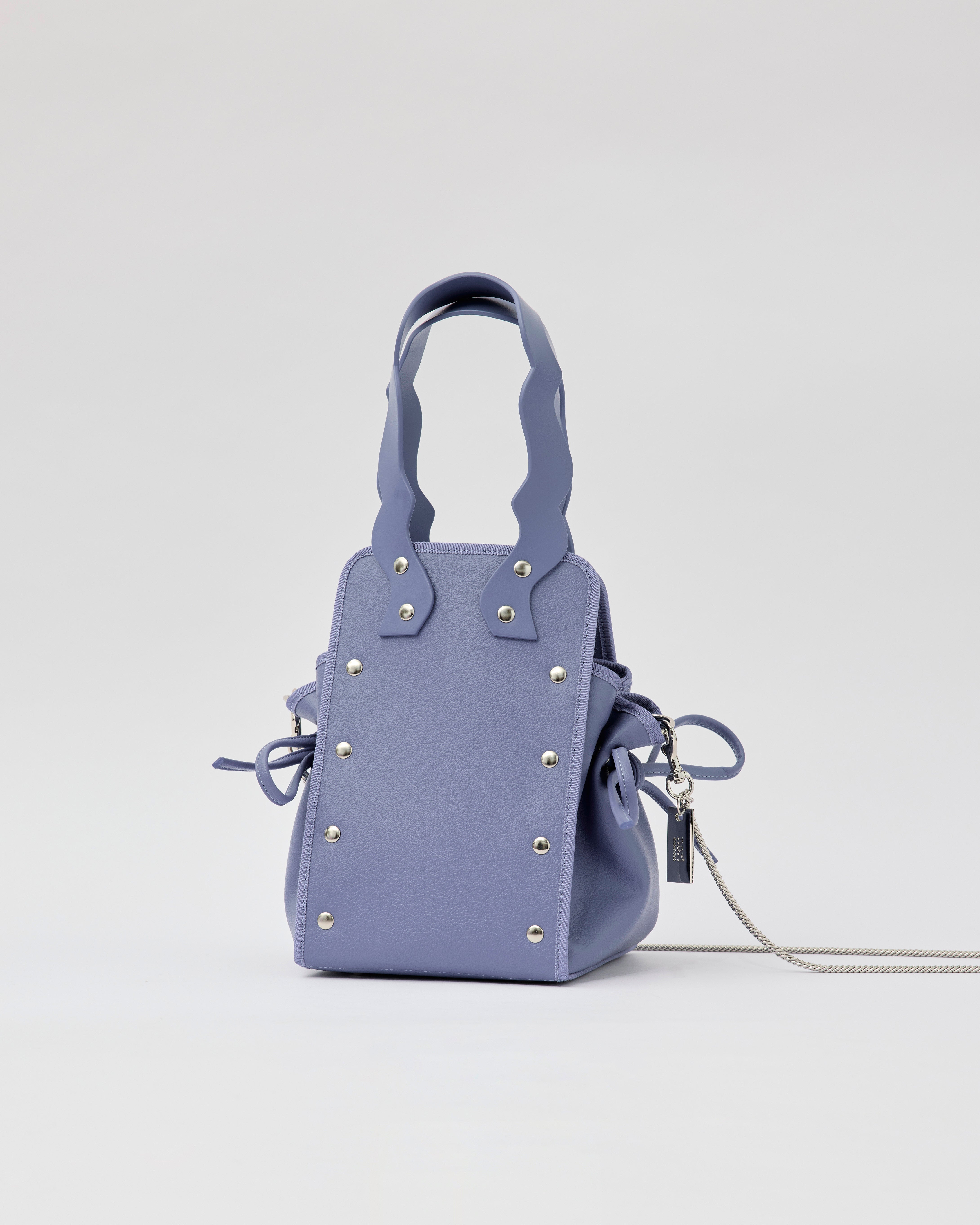 本革ハンドルの巾着型ハンドバッグ。サイドのドローストリングでシルエットを変化可能。500mlペットボトル対応サイズで内ポケット付き。取り外し可能なチェーンストラップでショルダー・クロスボディ両用。