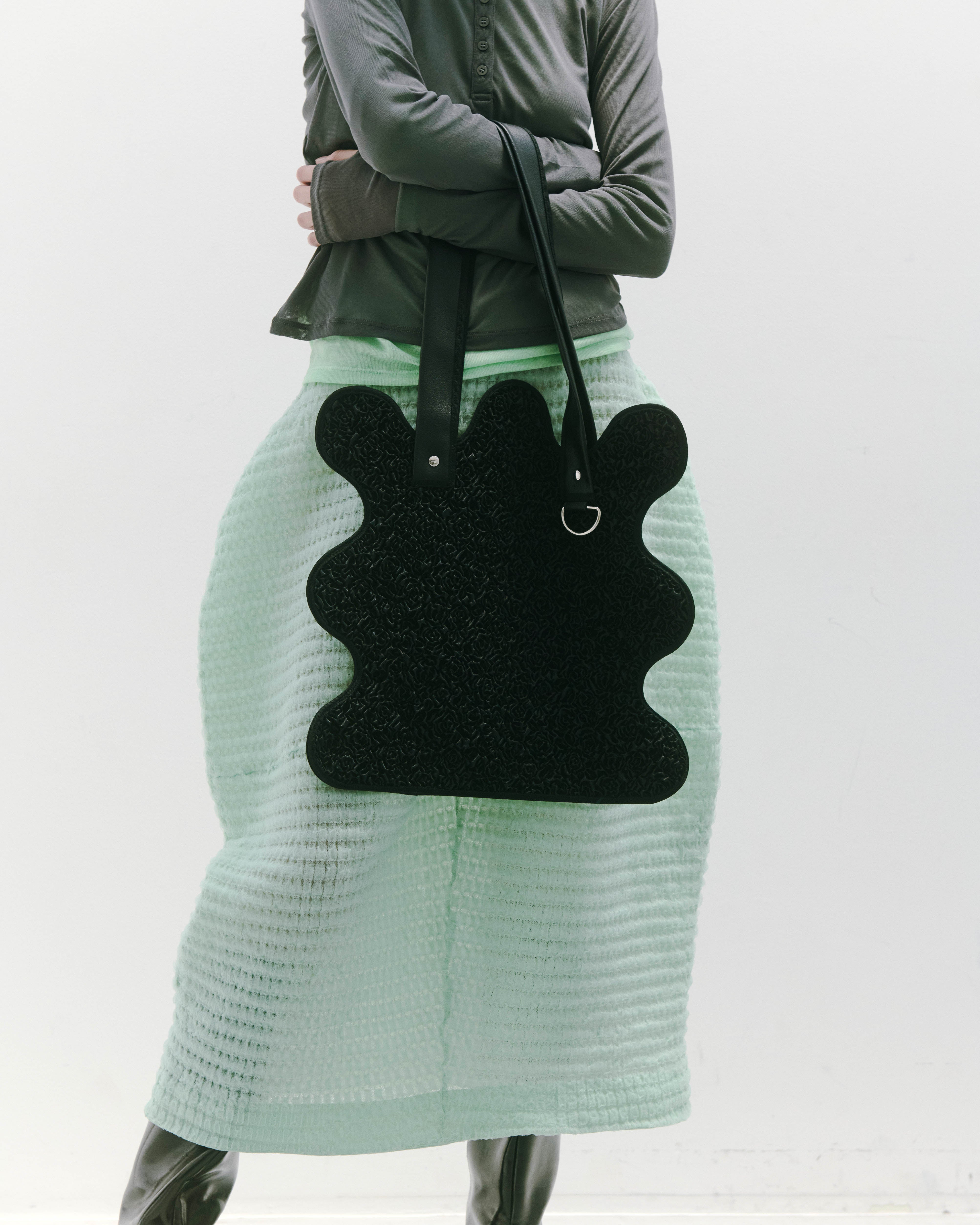 nori enomoto wave tote bag ブランドのシグネチャーである波打つシルエットが特徴のトートバッグ。A4対応サイズで、通勤・通学や日常使いにも便利。チャームが取り付けられるDカン付き。