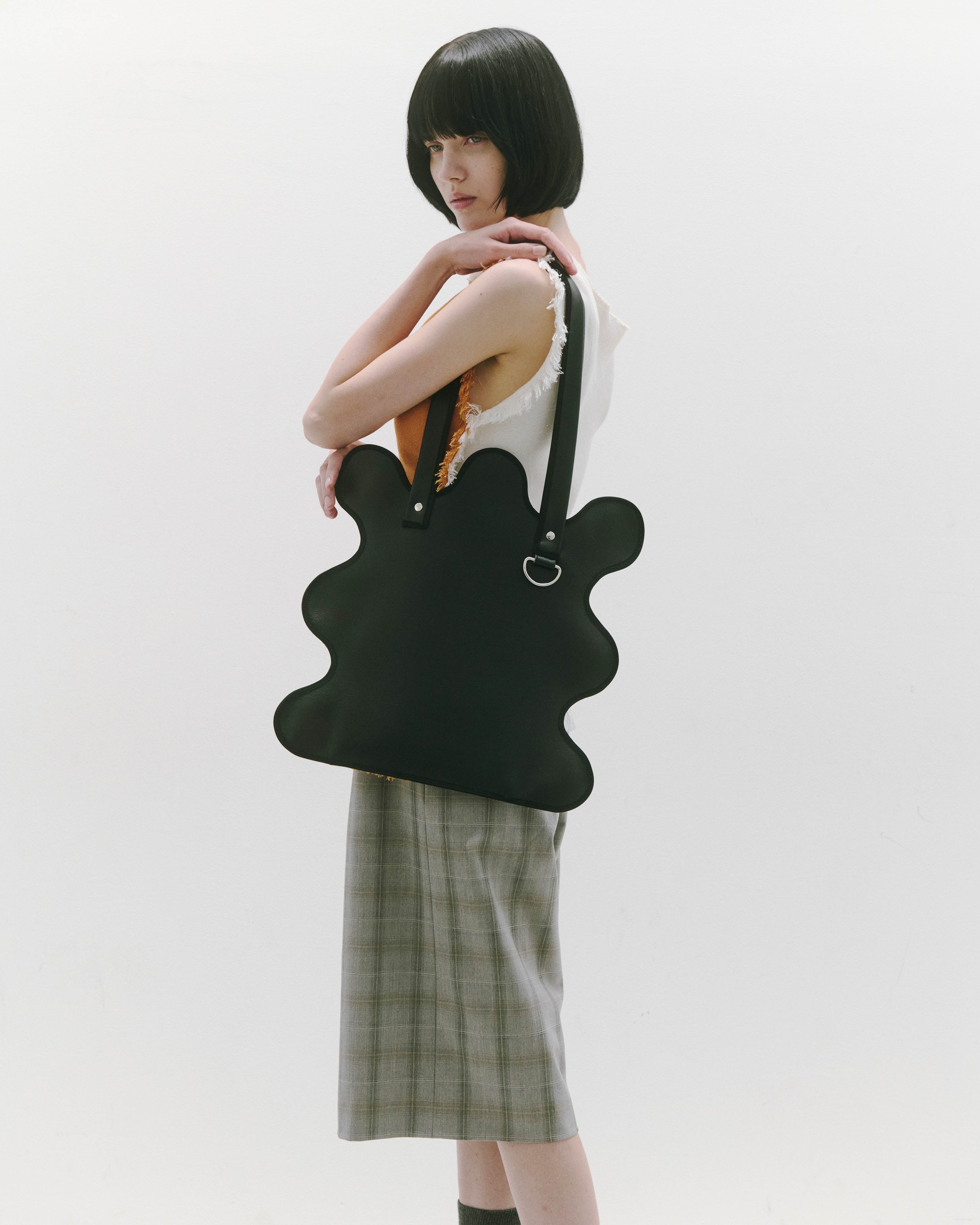 nori enomoto wave tote bag ブランドのシグネチャーである波打つシルエットが特徴のトートバッグ。A4対応サイズで、通勤・通学や日常使いにも便利。チャームが取り付けられるDカン付き。