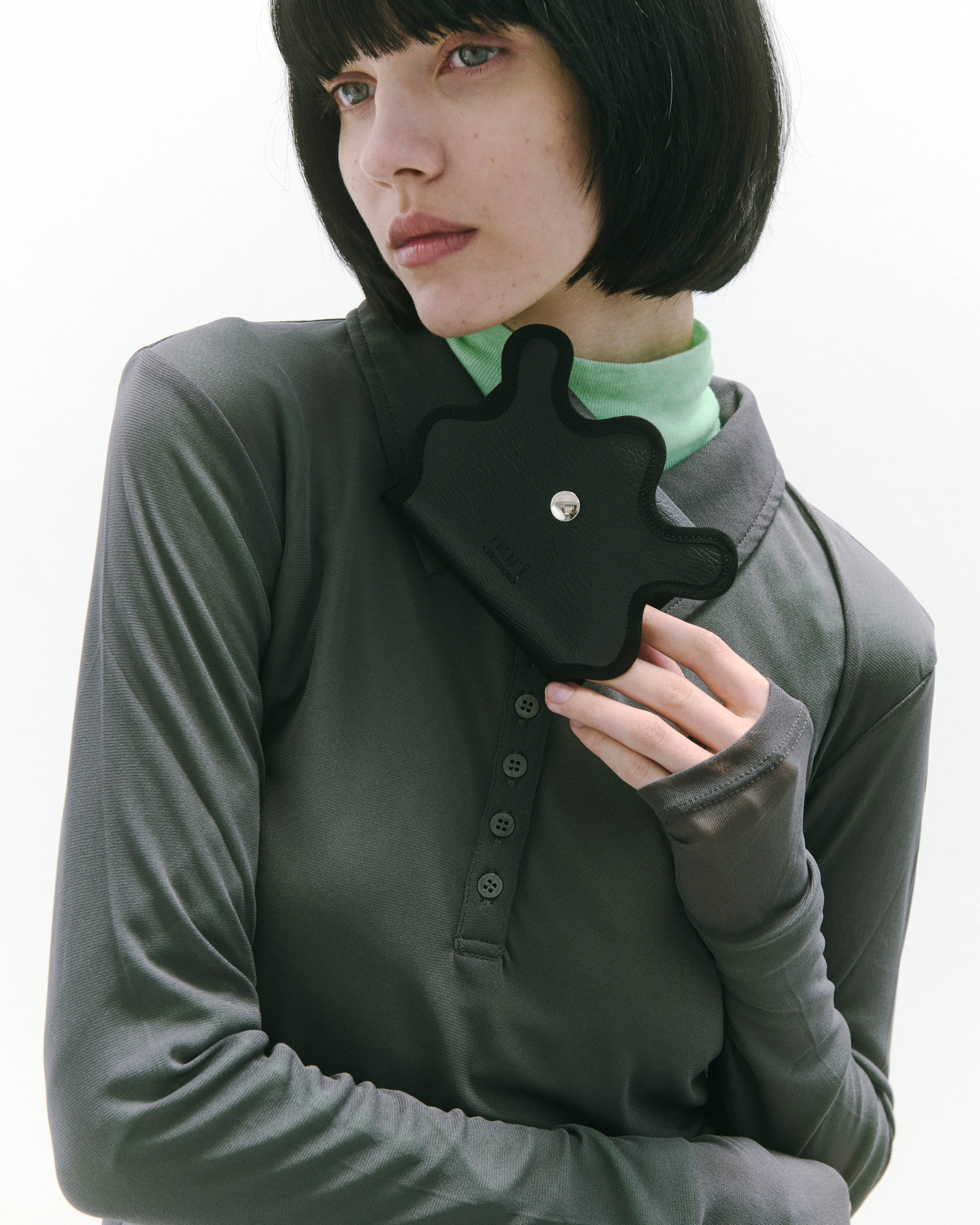 nori enomoto wave mini wallet 表面にエンボスロゴを施した三つ折り仕様のウォレット。小銭入れ、紙幣ポケット、カードスリットを備えた多機能コンパクト財布。