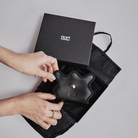 nori enomoto wave trifold wallet 表面にエンボスロゴを施した本革製の三つ折り財布。小銭入れ、紙幣ポケット、カードスリットを備えた実用的なレザーウォレット。