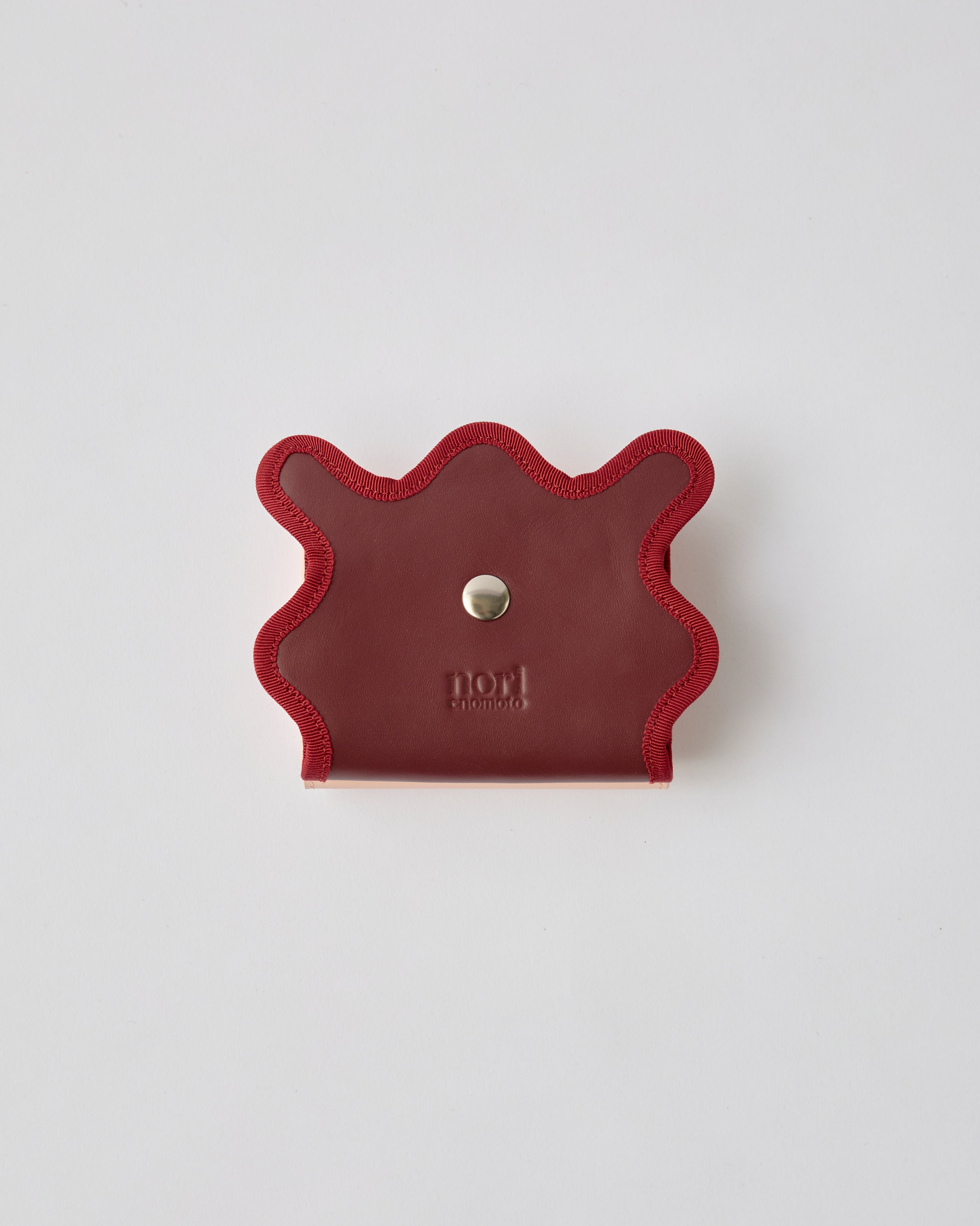 nori enomoto wave trifold wallet 表面にエンボスロゴを施した本革製の三つ折り財布。小銭入れ、紙幣ポケット、カードスリットを備えた実用的なレザーウォレット。