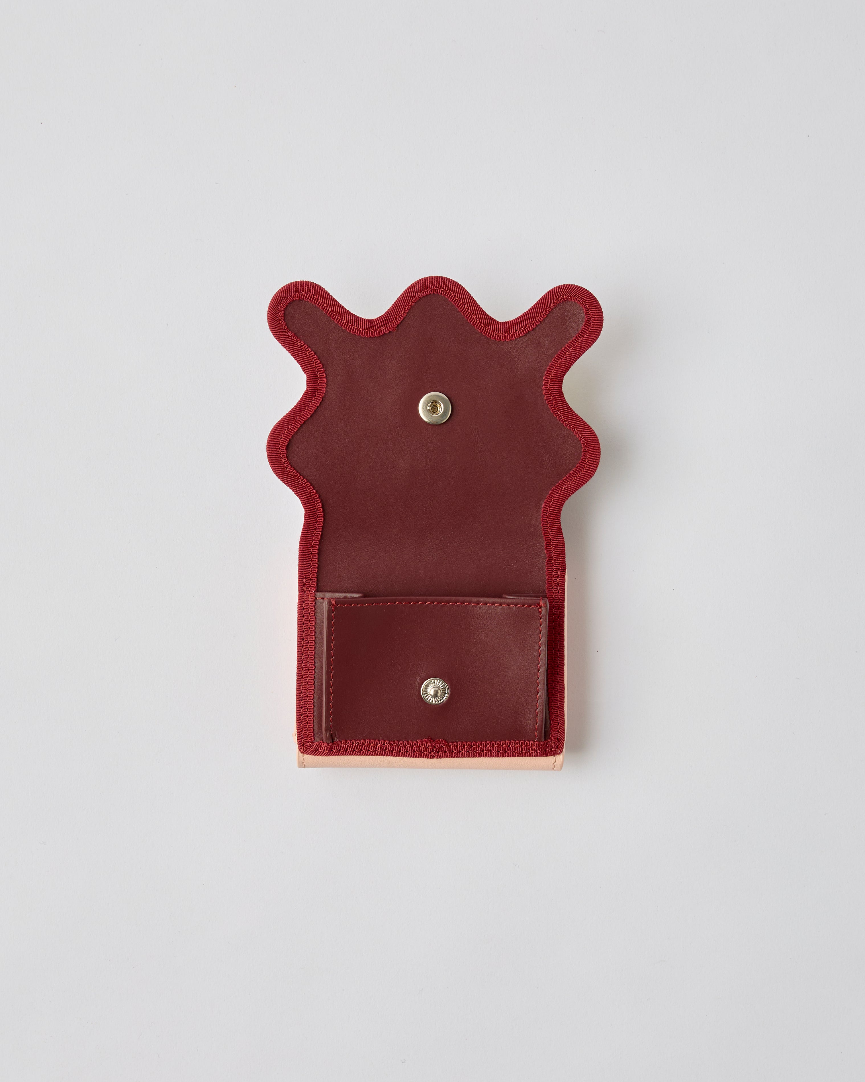 nori enomoto wave trifold wallet 表面にエンボスロゴを施した本革製の三つ折り財布。小銭入れ、紙幣ポケット、カードスリットを備えた実用的なレザーウォレット。