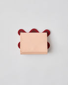 nori enomoto wave trifold wallet 表面にエンボスロゴを施した本革製の三つ折り財布。小銭入れ、紙幣ポケット、カードスリットを備えた実用的なレザーウォレット。