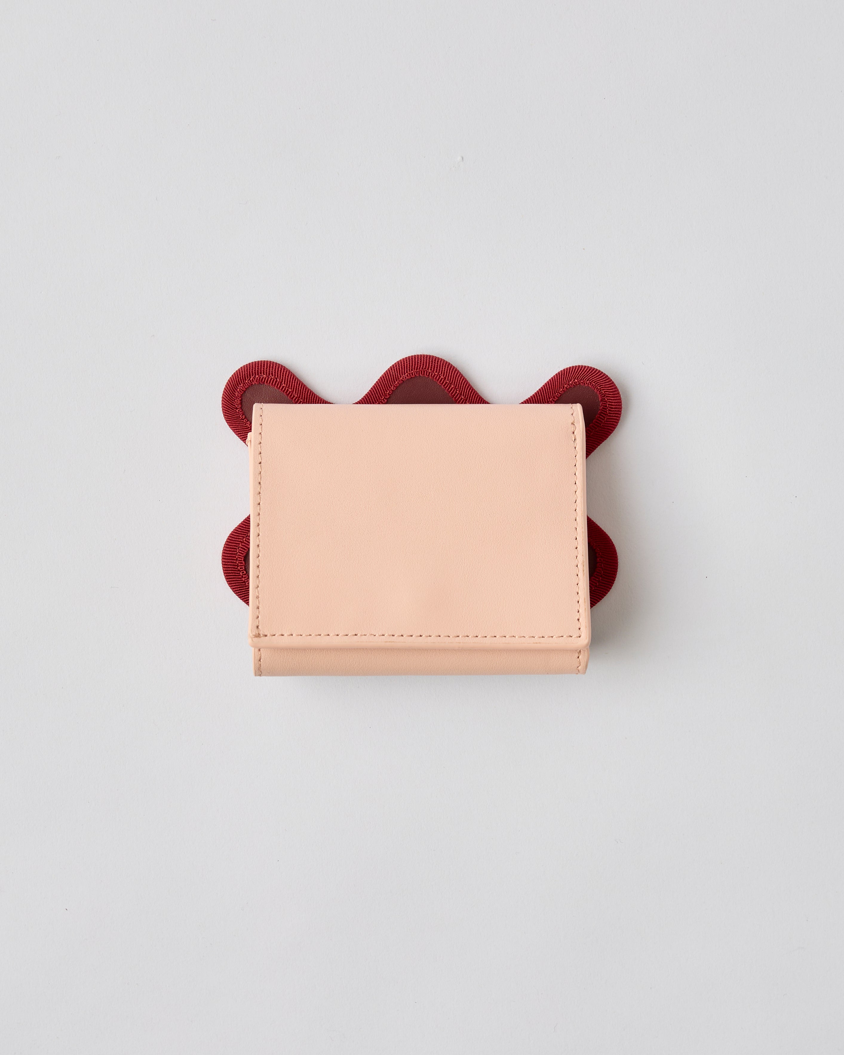 nori enomoto wave trifold wallet 表面にエンボスロゴを施した本革製の三つ折り財布。小銭入れ、紙幣ポケット、カードスリットを備えた実用的なレザーウォレット。