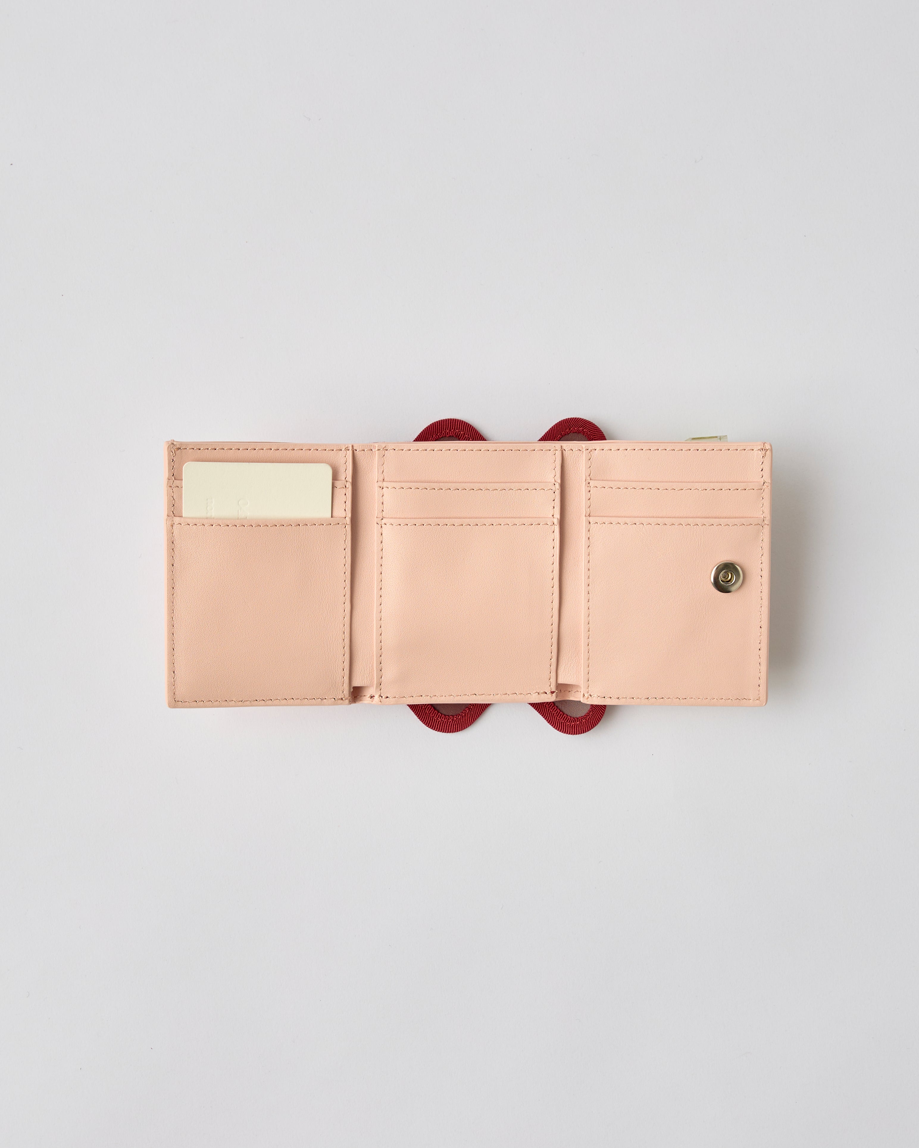 nori enomoto wave trifold wallet 表面にエンボスロゴを施した本革製の三つ折り財布。小銭入れ、紙幣ポケット、カードスリットを備えた実用的なレザーウォレット。