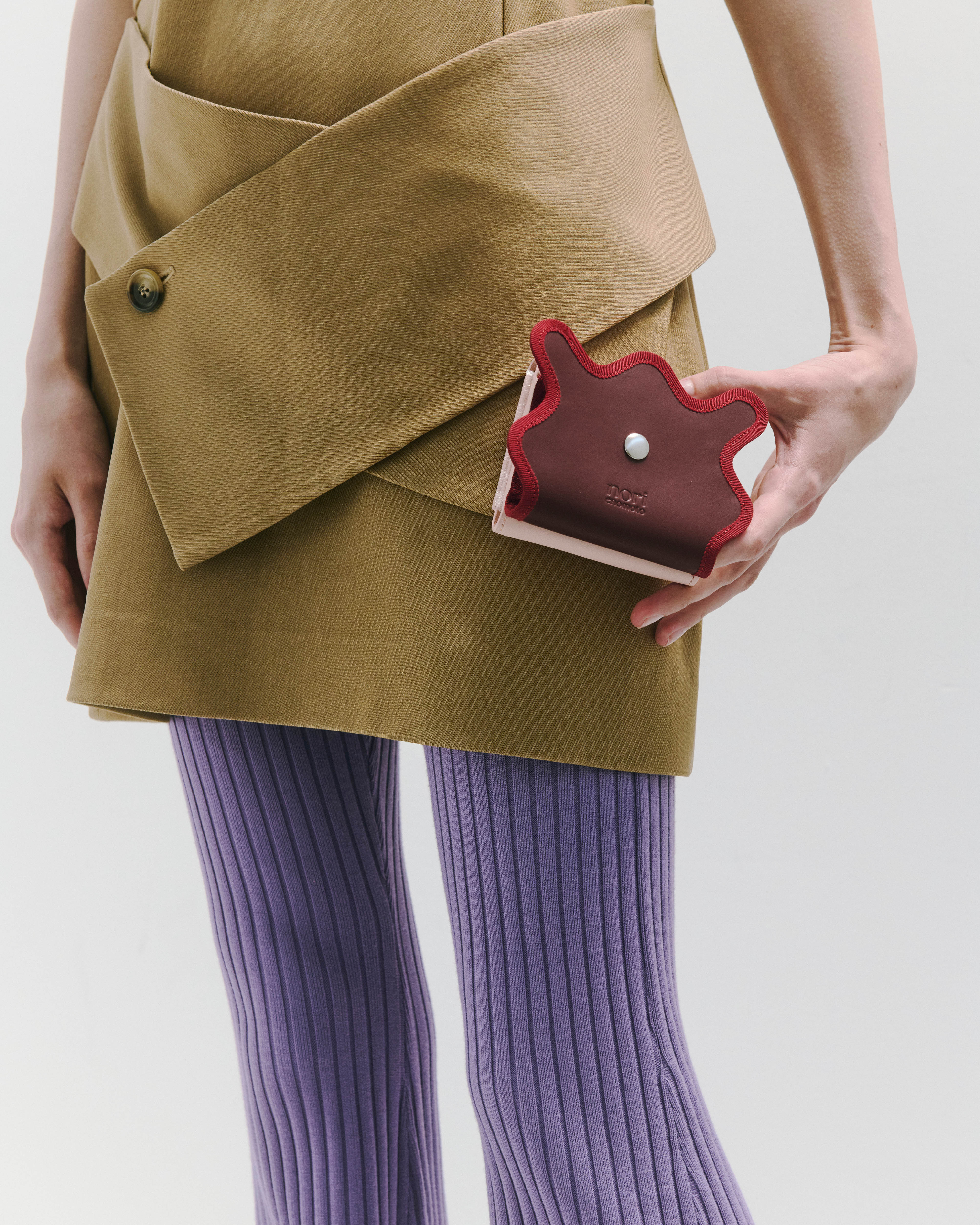 nori enomoto wave trifold wallet 表面にエンボスロゴを施した本革製の三つ折り財布。小銭入れ、紙幣ポケット、カードスリットを備えた実用的なレザーウォレット。