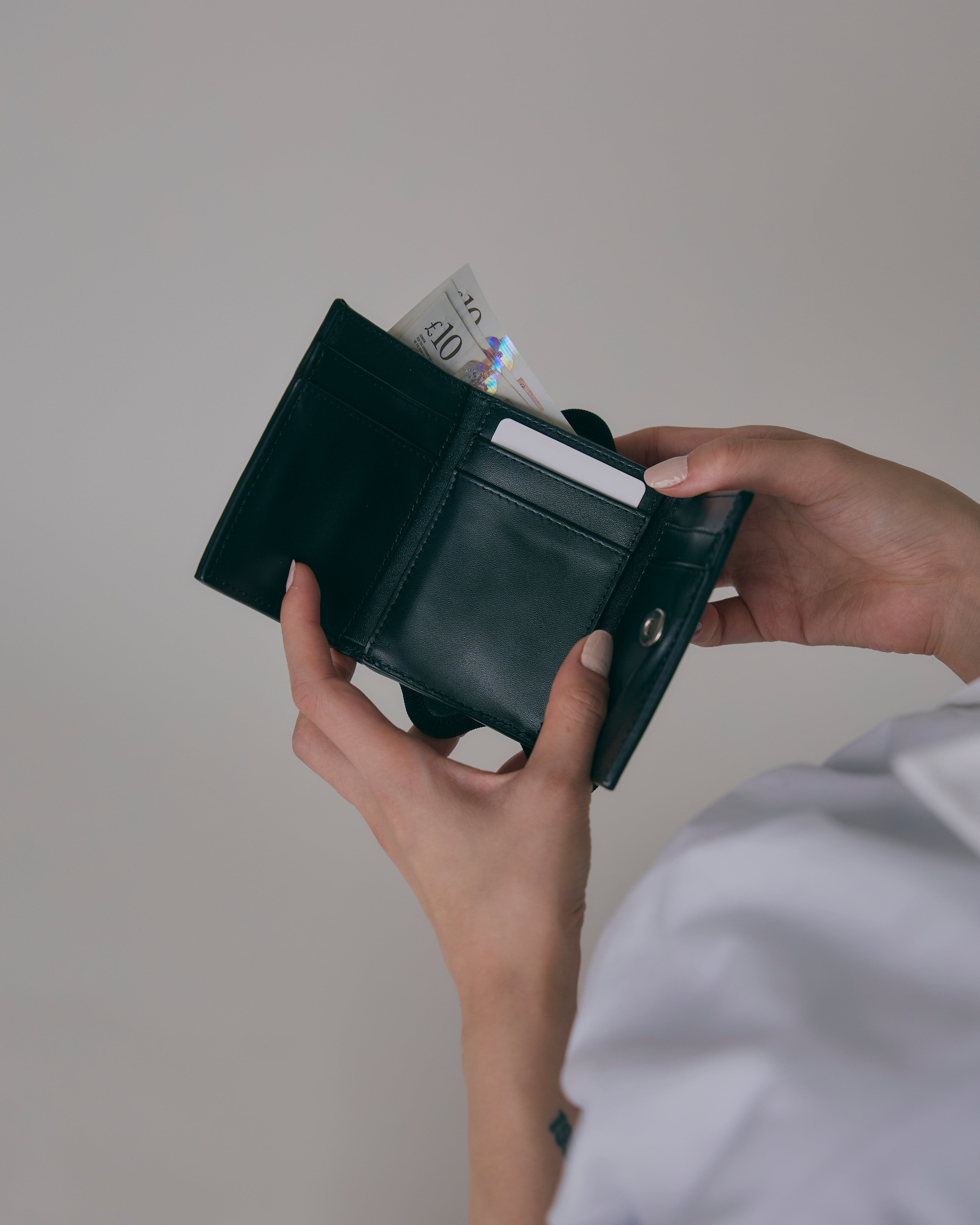 nori enomoto wave trifold wallet 表面にエンボスロゴを施した本革製の三つ折り財布。小銭入れ、紙幣ポケット、カードスリットを備えた実用的なレザーウォレット。