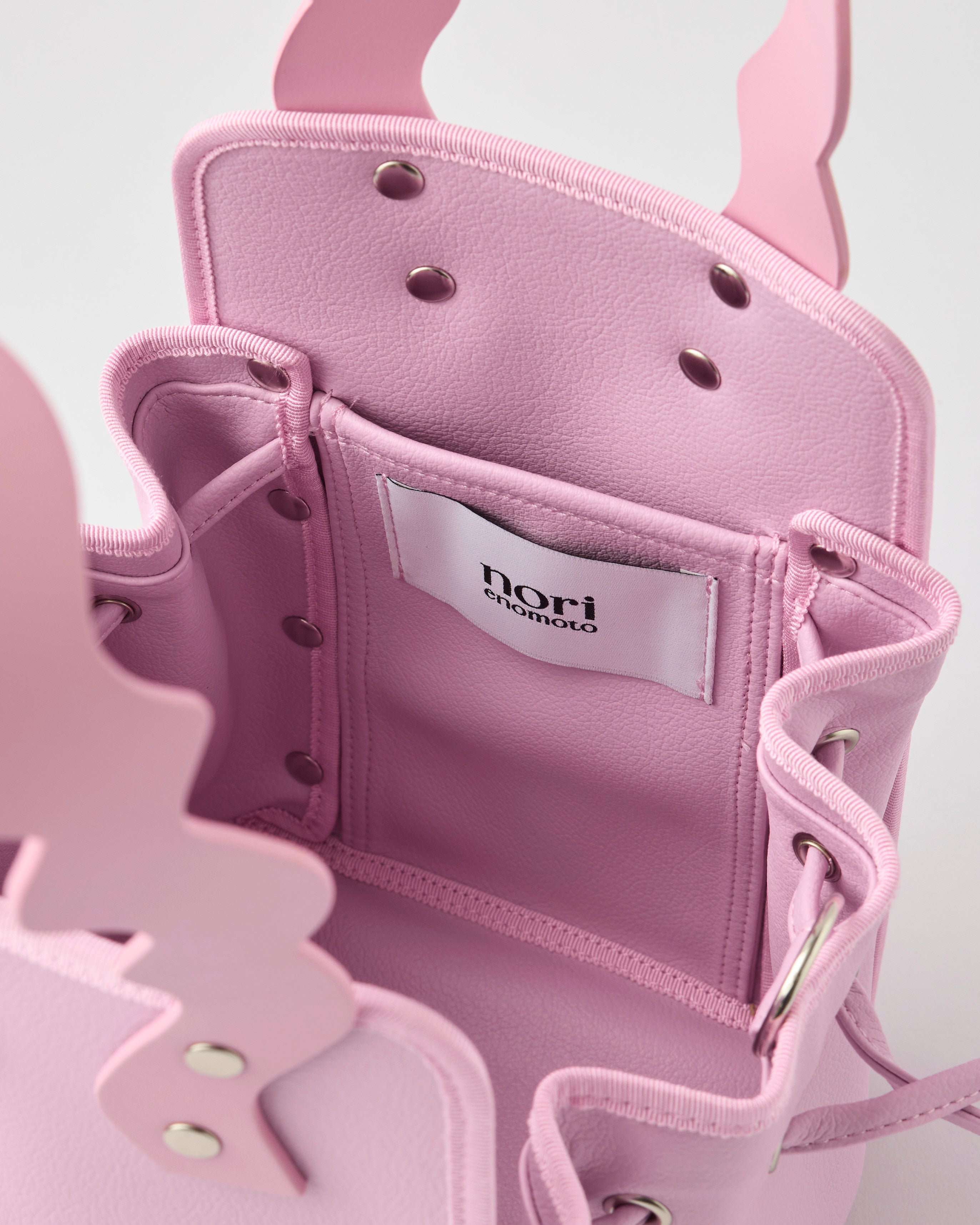 本革ハンドルの巾着型ハンドバッグ。サイドのドローストリングでシルエットを変化可能。500mlペットボトル対応サイズで内ポケット付き。取り外し可能なチェーンストラップでショルダー・クロスボディ両用。