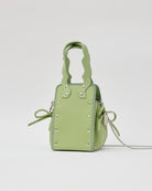 本革ハンドルの巾着型ハンドバッグ。サイドのドローストリングでシルエットを変化可能。500mlペットボトル対応サイズで内ポケット付き。取り外し可能なチェーンストラップでショルダー・クロスボディ両用。