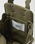 本革ハンドルの巾着型ハンドバッグ。サイドのドローストリングでシルエットを変化可能。500mlペットボトル対応サイズで内ポケット付き。取り外し可能なチェーンストラップでショルダー・クロスボディ両用。