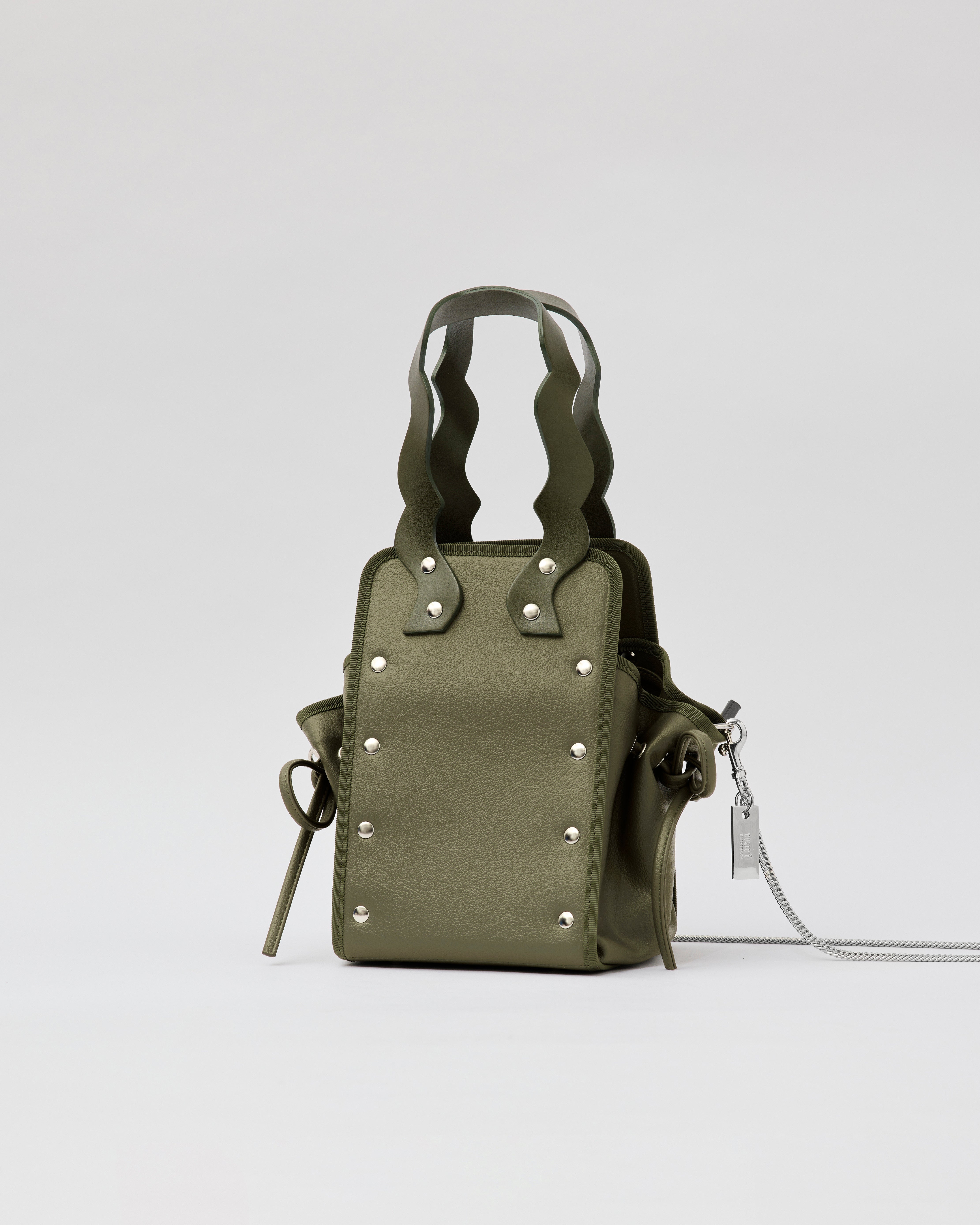 本革ハンドルの巾着型ハンドバッグ。サイドのドローストリングでシルエットを変化可能。500mlペットボトル対応サイズで内ポケット付き。取り外し可能なチェーンストラップでショルダー・クロスボディ両用。