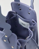 本革ハンドルの巾着型ハンドバッグ。サイドのドローストリングでシルエットを変化可能。500mlペットボトル対応サイズで内ポケット付き。取り外し可能なチェーンストラップでショルダー・クロスボディ両用。