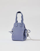 本革ハンドルの巾着型ハンドバッグ。サイドのドローストリングでシルエットを変化可能。500mlペットボトル対応サイズで内ポケット付き。取り外し可能なチェーンストラップでショルダー・クロスボディ両用。