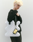 nori enomoto　wave tote bag　ブランドのシグネチャーである波打つシルエットが特徴のトートバッグ。A4対応サイズで、通勤・通学や日常使いにも便利。チャームが取り付けられるDカン付き。